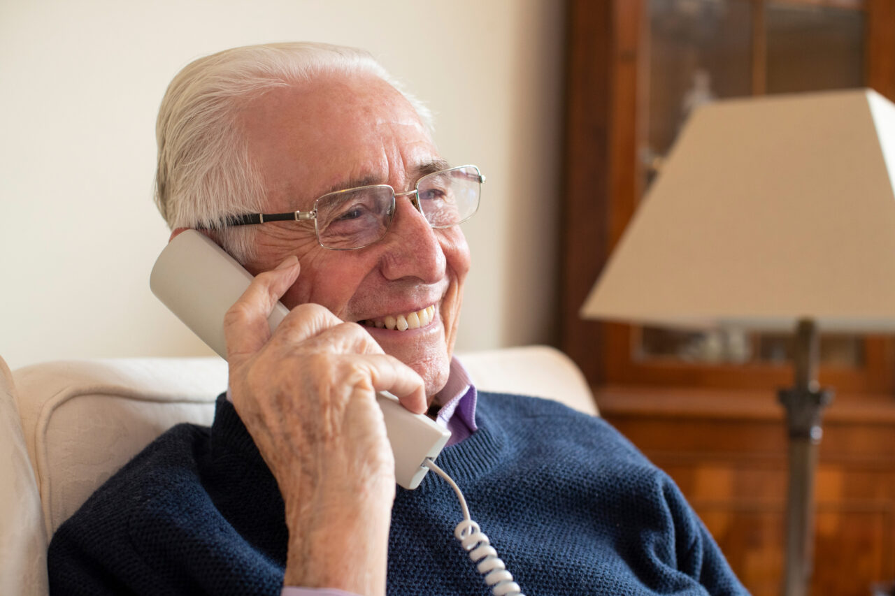 Smiling older Man Using Phone At Home