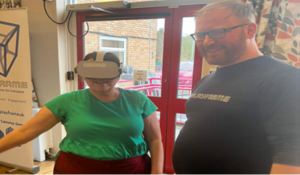 A woman with a VR headset on next to a man smiling