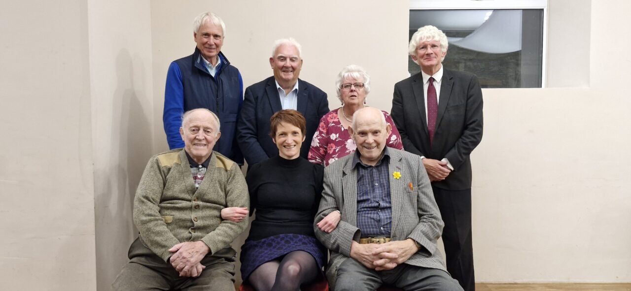 Comisiynydd Pobl Hŷn Cymru, Rhian Bowen-Davies, yn y llun ochr yn ochr â: Alf Thomas [yn eistedd i'w dde] ac Elwyn Williams [yn eistedd i'w chwith]. Yn sefyll, o'r chwith i'r dde, John Edge, Keith Evans, Mair Davies a Peter Davies. // Older People’s Commissioner for Wales, Rhian Bowen-Davies, pictured alongside: Alf Thomas [seated to her right] and Elwyn Wiliams [seated to her left]. Standing, from left to right, John Edge, Keith Evans, Mair Davies and Peter Davies.