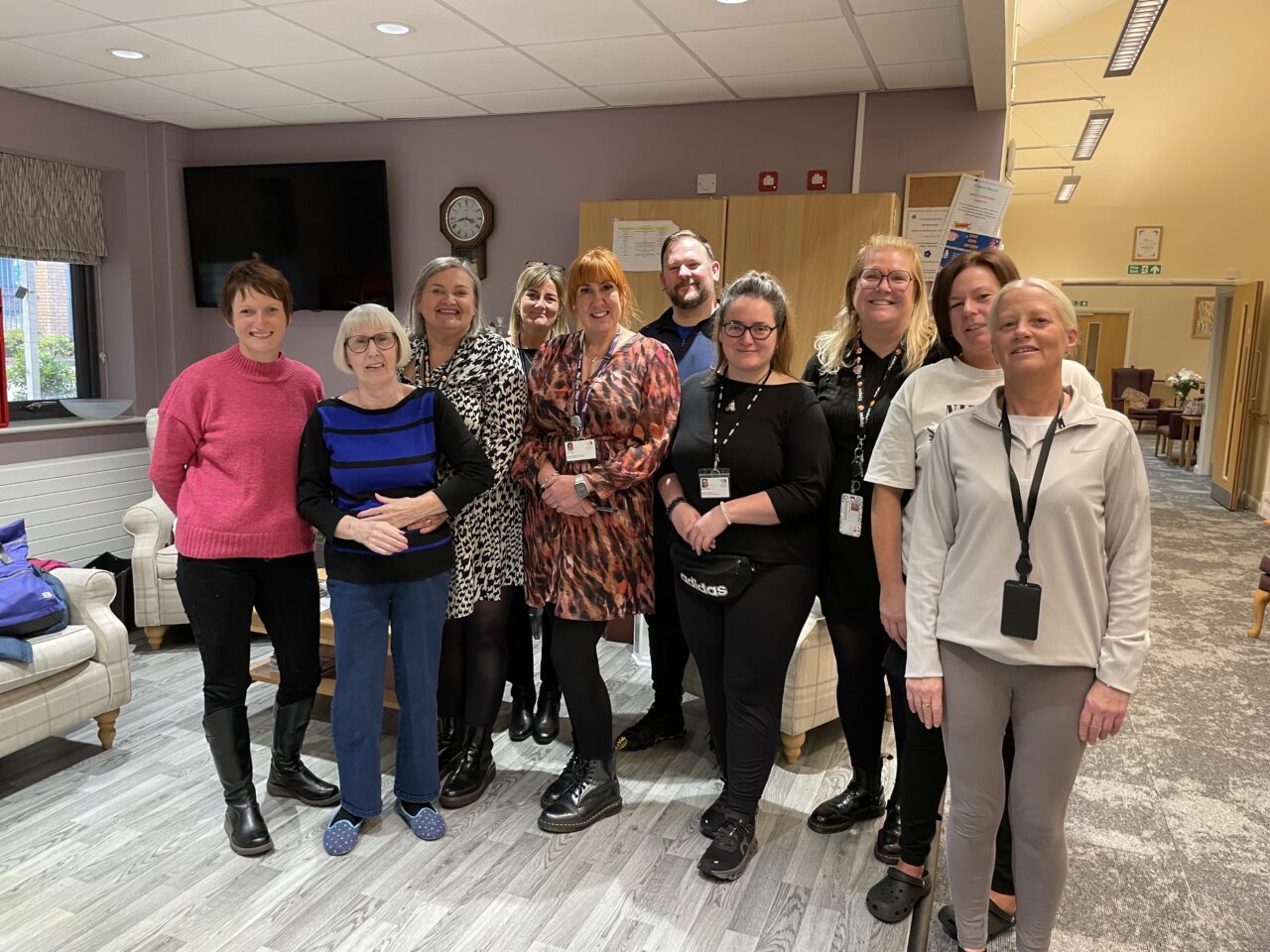 Comisiynydd Pobl Hŷn Cymru, Rhian Bowen-Davies (chwith eithaf), yn y llun ochr yn ochr â staff a phreswylwyr Tŷ Gurnos, yn eu cyntedd. // Older People's Commissioner for Wales, Rhian Bowen-Davies (far left), pictured alongside staff and residents of Ty Gurnos, in their foyer.