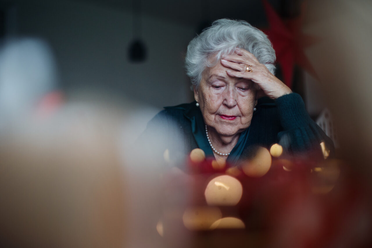 Unhappy senior woman sitting alone and crying