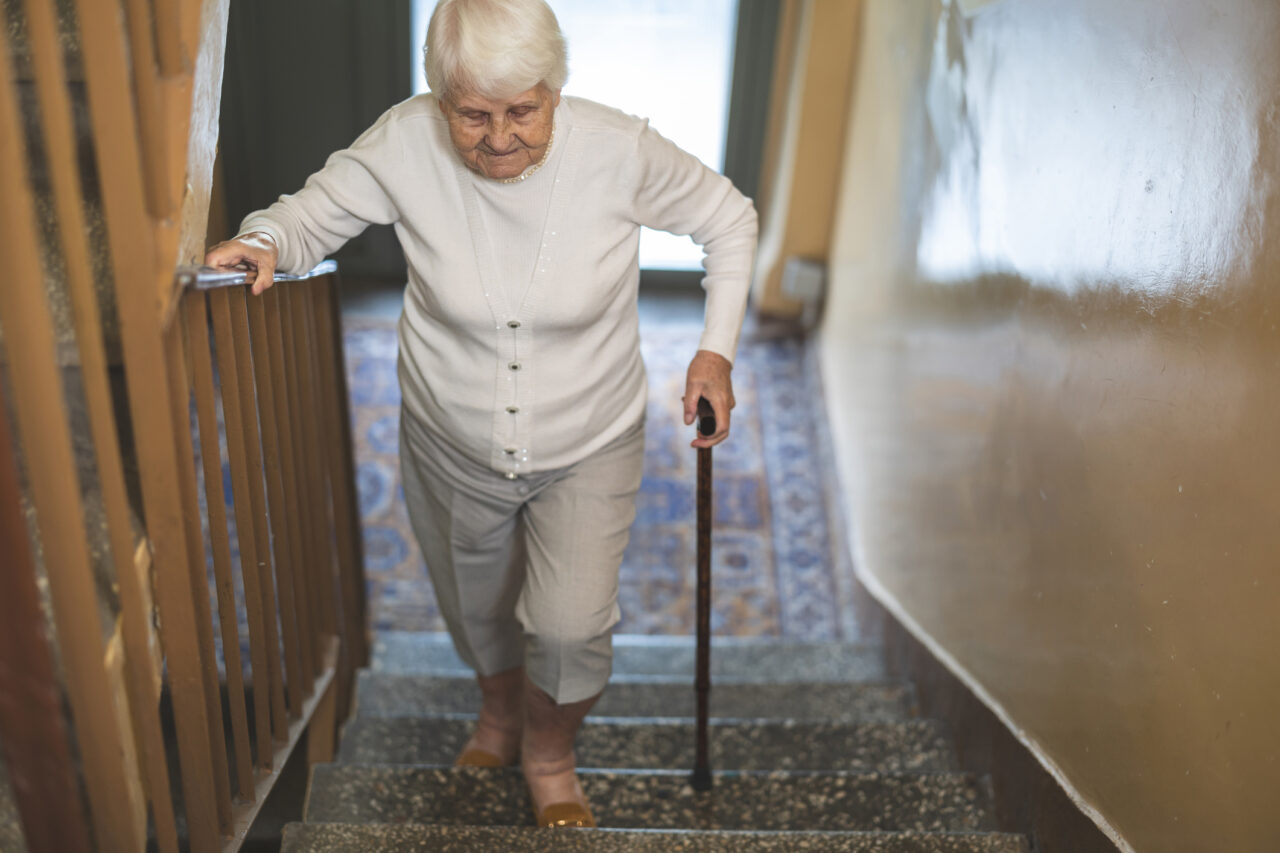 Older woman walking up the stairs in her house