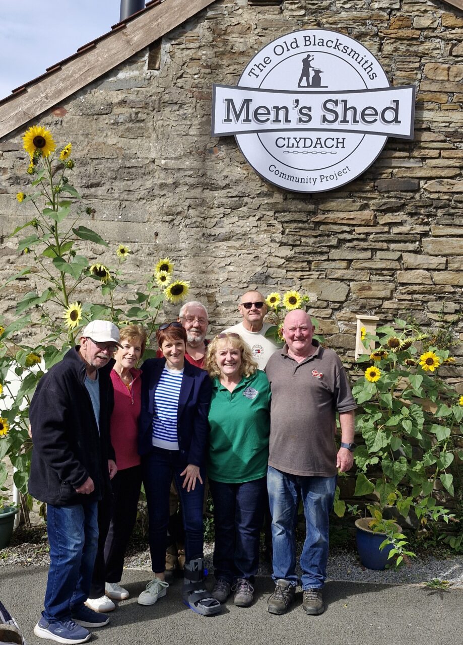 Comisiynydd Pobl Hŷn Cymru, Rhian Bowen-Davies (yng nghanol y rhes flaen), yn cael ei ffotograffu ochr yn ochr ag aelodau o 'Men's Shed' Clydach. // Older People's Commissioner for Wales, Rhian Bowen-Davies (centre-front), pictured alongside members of Clydach's Men's Shed.